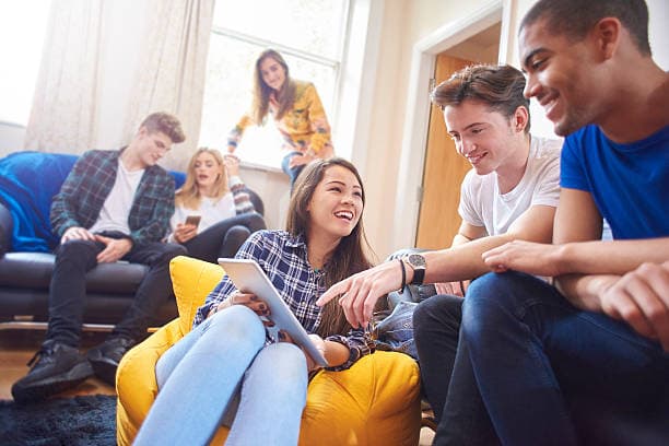 Group of international students relaxing and socializing in a shared accommodation in the UK