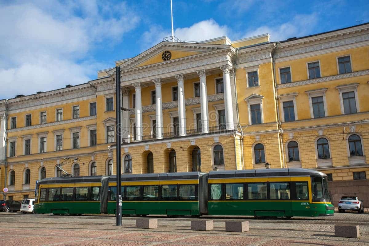 University of Helsinki – Finland’s Leading Research University Main building of the University of Helsinki in Finland, with neoclassical architecture and Finnish flags waving in the background.