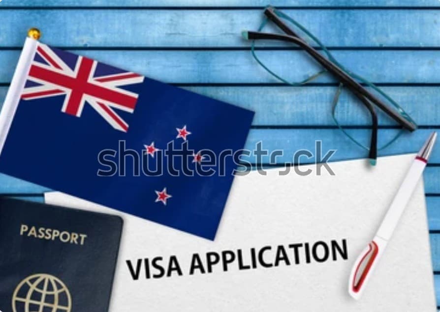 New Zealand flag with passport and visa application form on blue background, symbolizing immigration or student visa process.