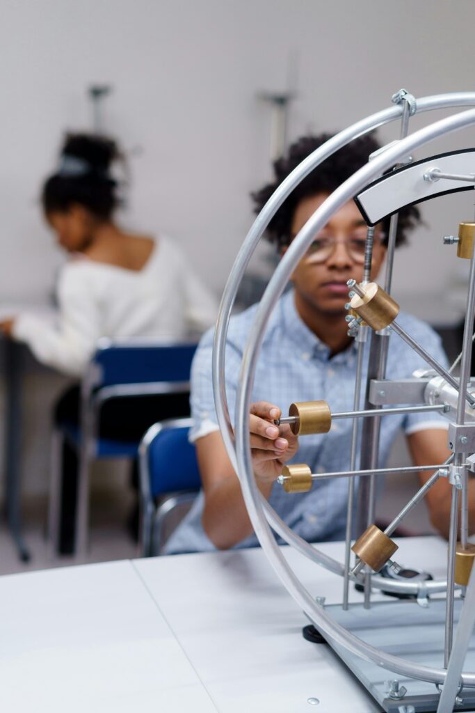 Student adjusting a physics/engineering apparatus in a university lab, representing hands-on research and collaborative R&D opportunities.