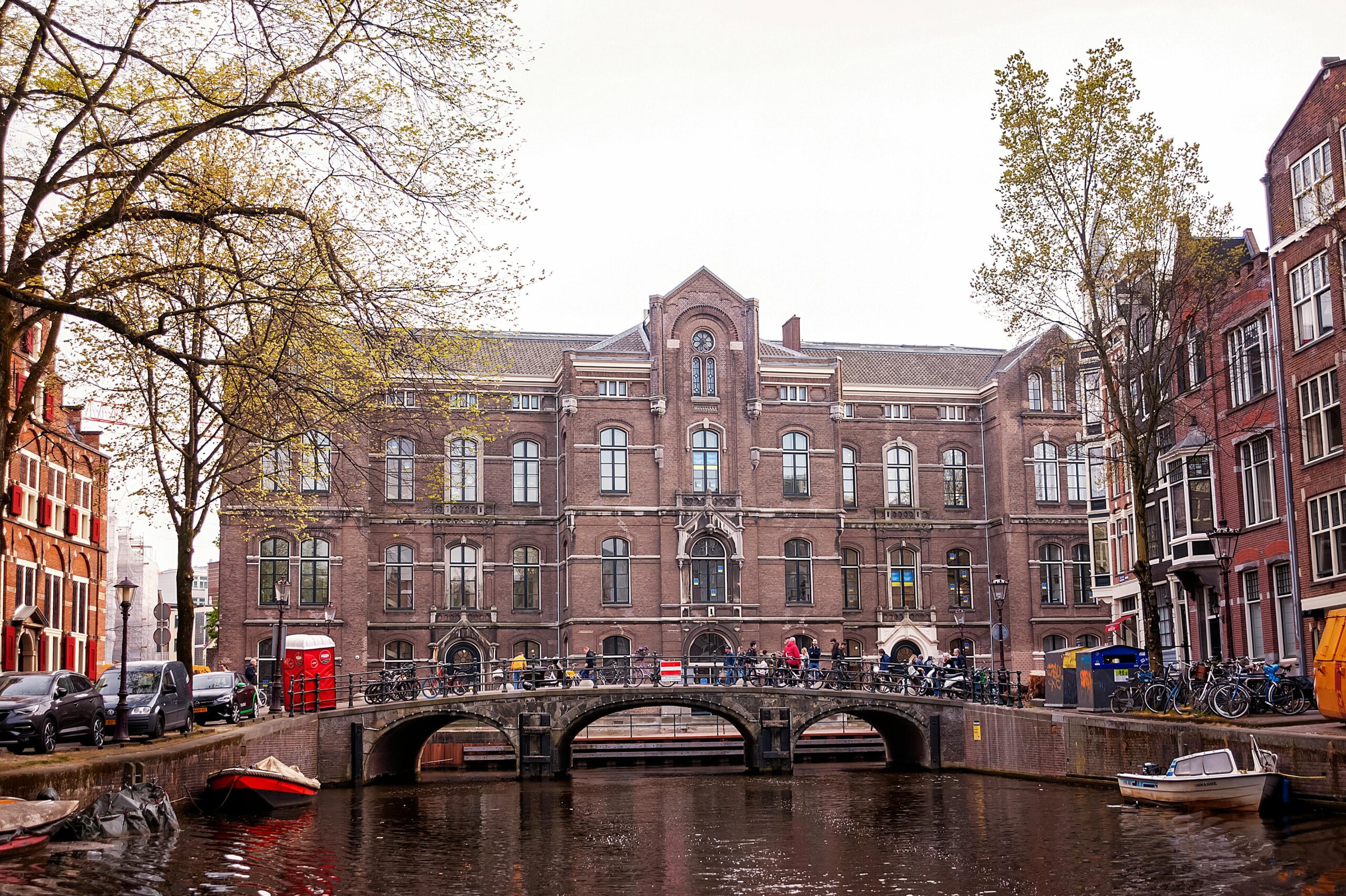 A historic building of the University of Amsterdam located beside a canal, representing Dutch education and European academic excellence.