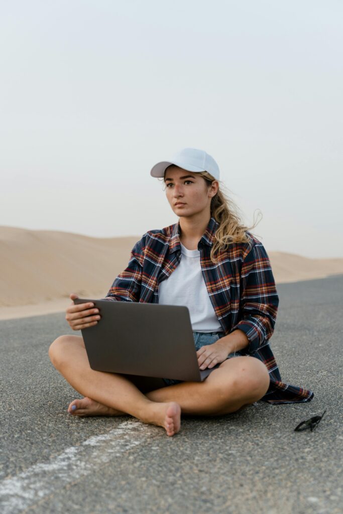 Student using laptop in UAE desert — representing modern technology and digital education life.