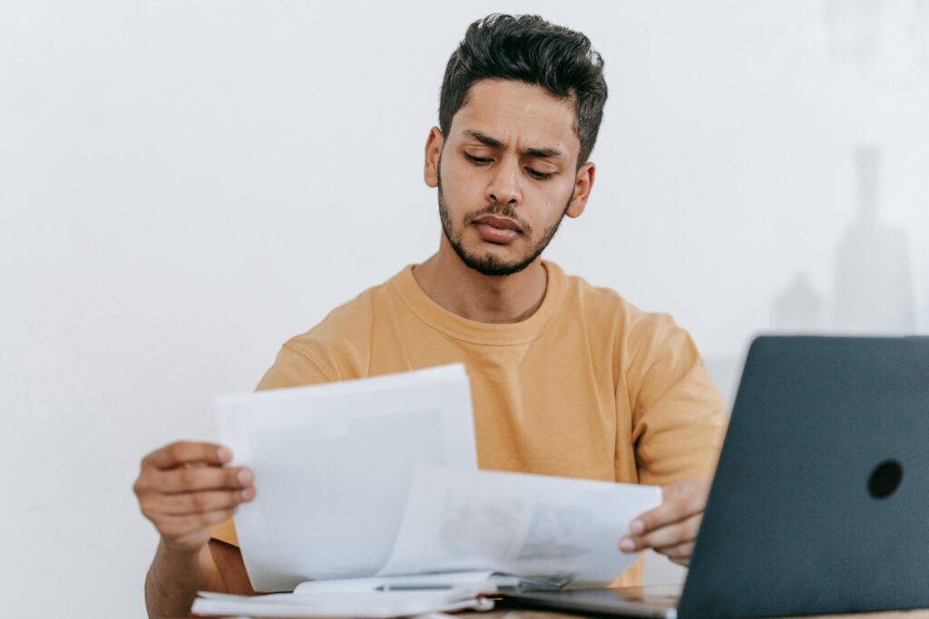Indian student reviewing papers beside a laptop, symbolizing internships, campus placements, and post-study career planning in India.