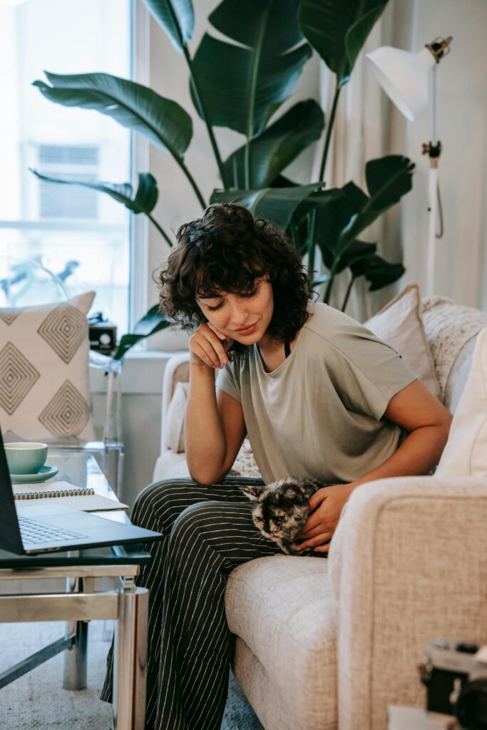 Student sitting on a couch with a laptop and coffee, representing daily student life and culture in Austria.