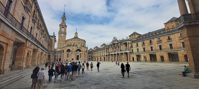 The Universidad Laboral de Gijón in Asturias, Spain, featuring grand neoclassical architecture and a large open courtyard with visitors walking.