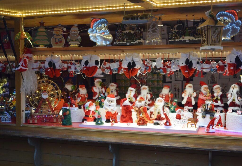 Christmas market stall in France displaying Santa decorations, showcasing French culture and festive traditions