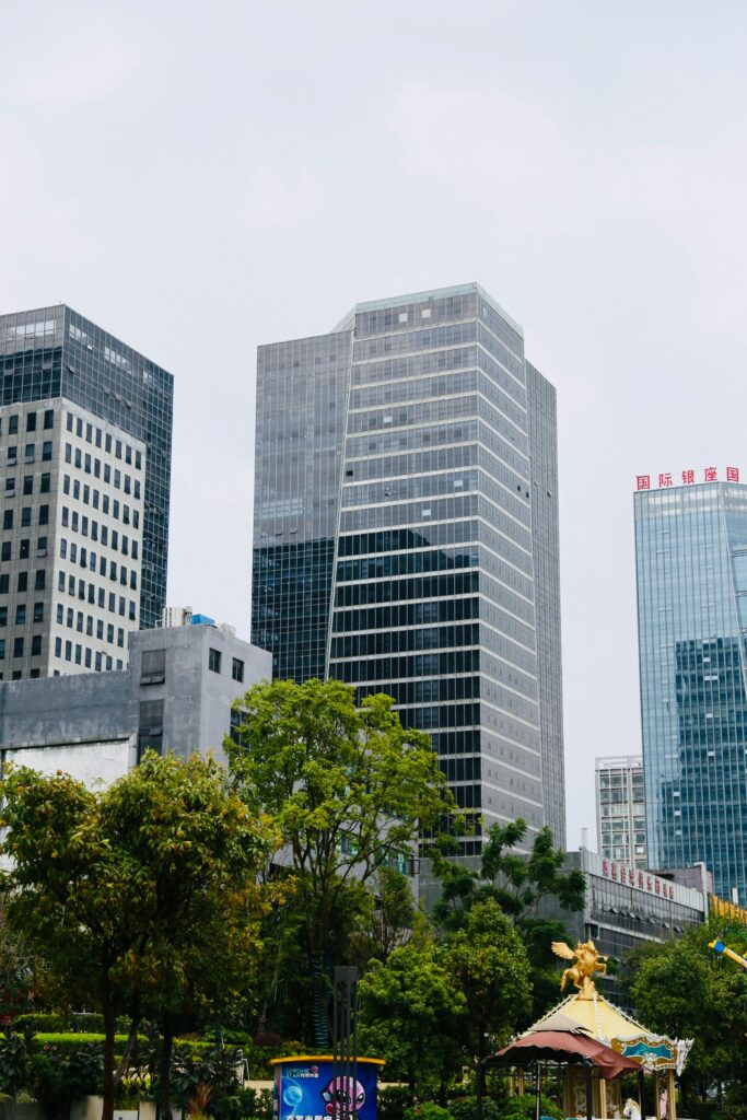 Modern city skyline in China with tall glass skyscrapers, greenery, and an urban park area — representing top cities and campuses students can consider for studying in China.
