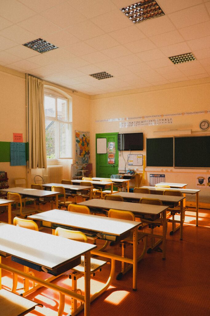 A bright French classroom with empty desks and sunlight streaming through the windows, representing the learning environment and academic atmosphere in France.