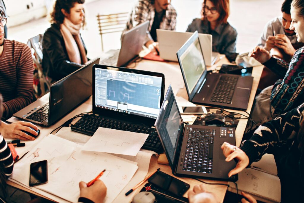 Group of international students working together on laptops during a project, representing career opportunities and post-study employment in Canada.