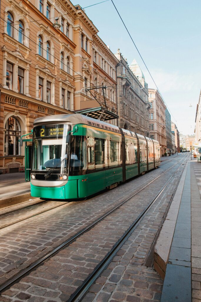 Green tram on the streets of Helsinki, Finland representing modern lifestyle, convenience, and excellent student life experience.