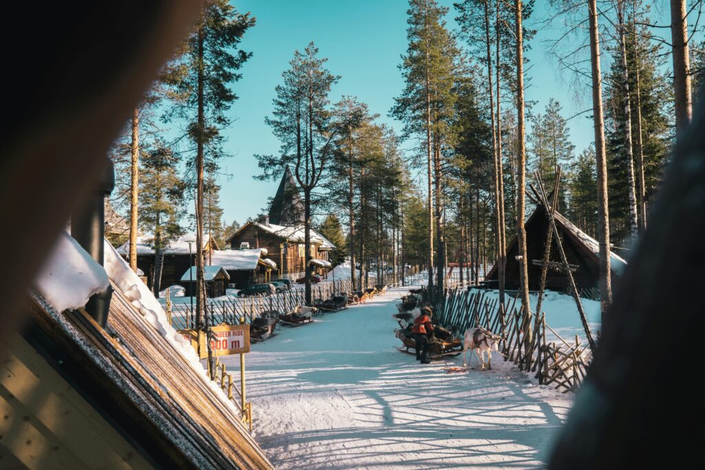 A snowy winter village in Finland surrounded by pine trees, representing a peaceful and welcoming study destination for international students.