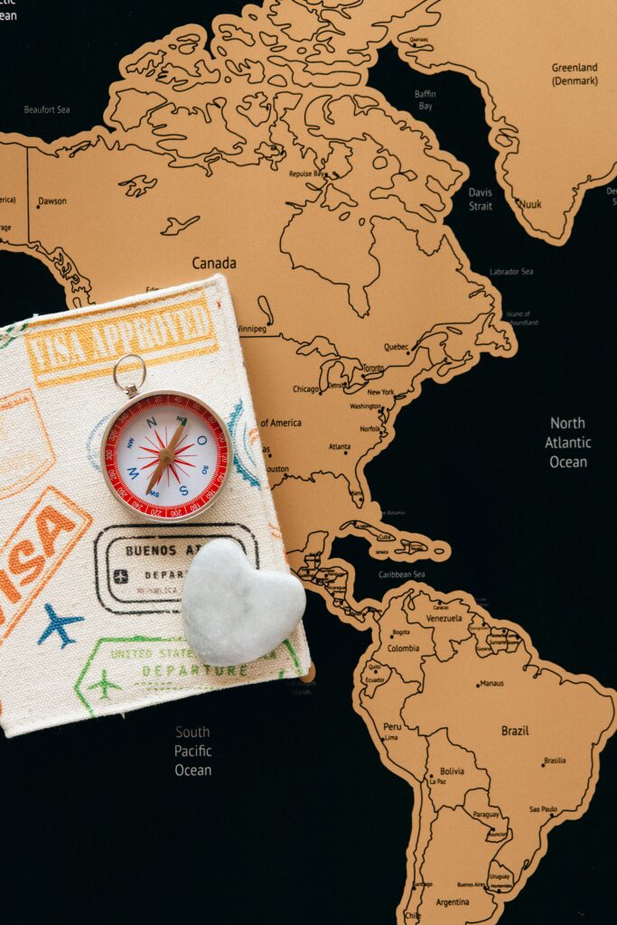 A travel map with a compass, visa-stamped notebook, and a heart-shaped stone symbolizing the Denmark student visa journey.