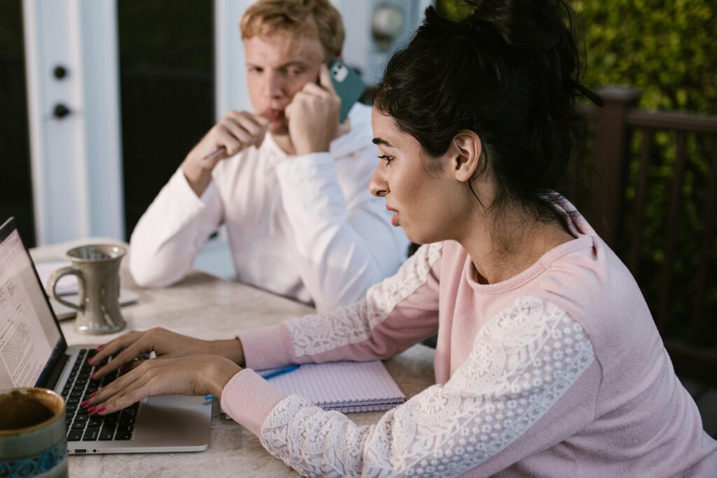 Two young professionals working together on a laptop, representing internship and job opportunities for international students in Australia.