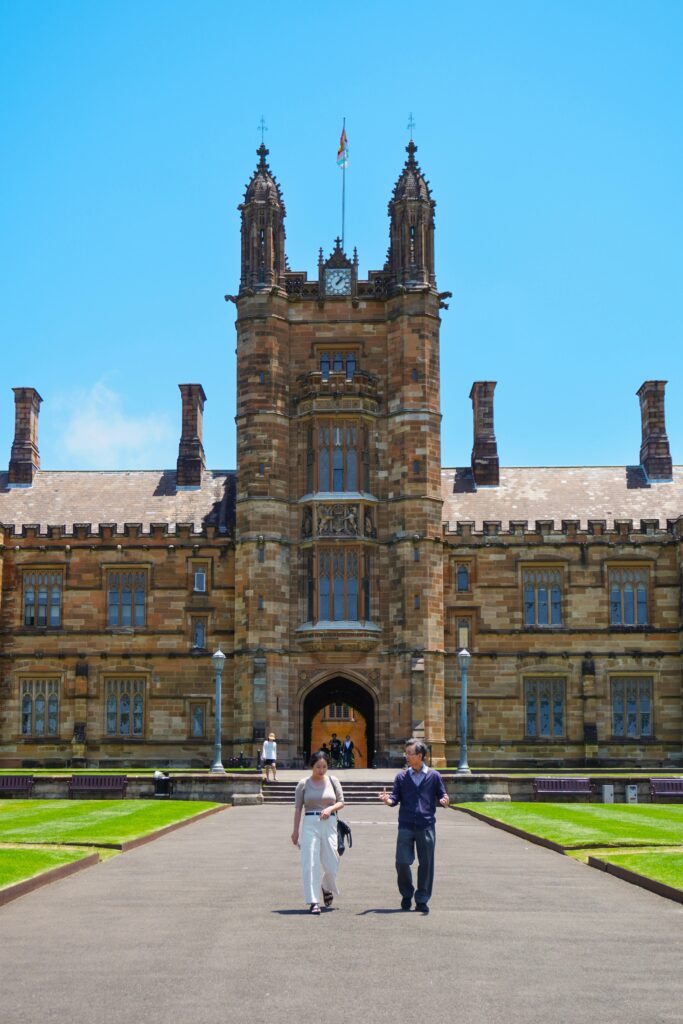 Historic university building with visitors in Sydney, Australia, representing world-class education and scholarship opportunities for international students.