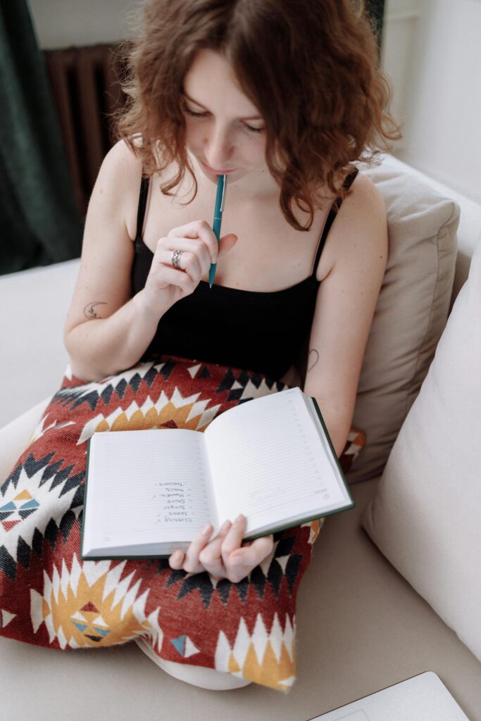 Woman holding a pen and notebook while reviewing a study checklist, representing preparation for studying in France.