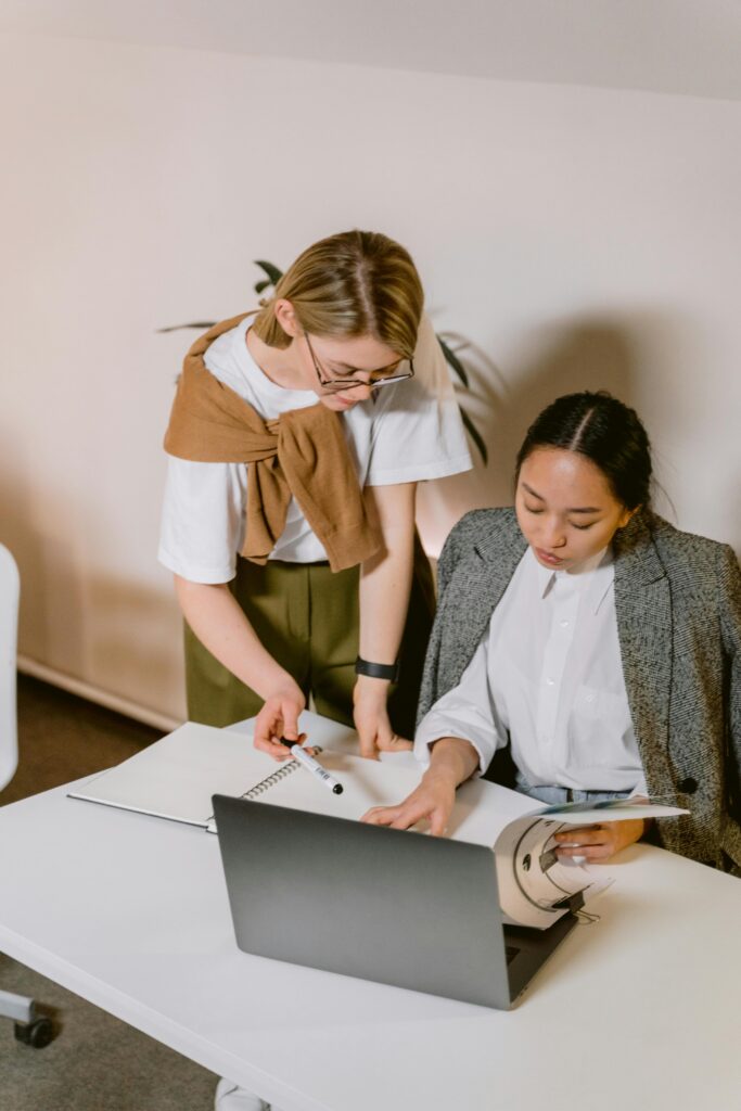Two professionals reviewing a document and laptop together — representing accuracy, verification, and responsible information sharing for Study Silently’s Disclaimer section.