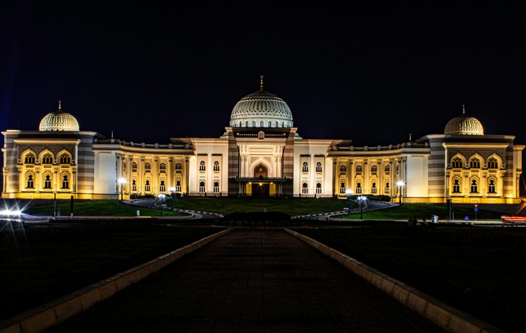 Illuminated university building with domes and arches at night in the UAE, representing higher education excellence and architectural beauty.