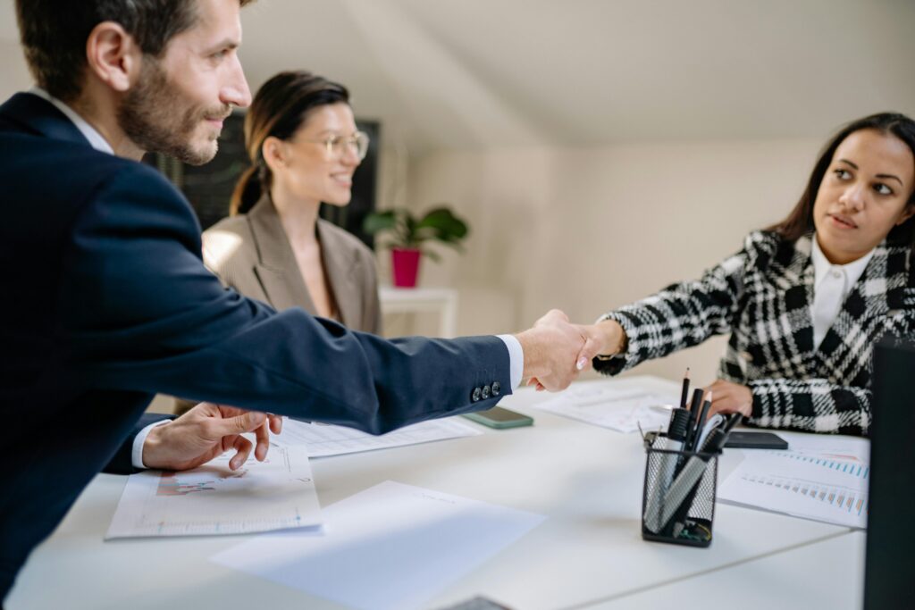 Professionals shaking hands during a meeting, representing strong career growth and alumni networking opportunities after studying in Finland