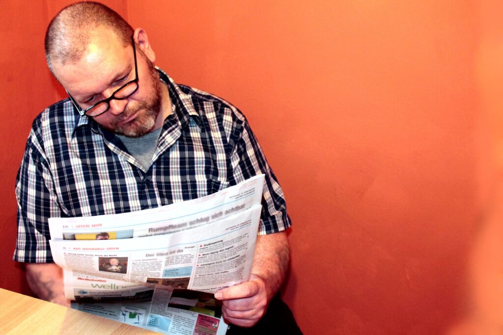 A man reading a newspaper while staying updated with global education and study abroad news.