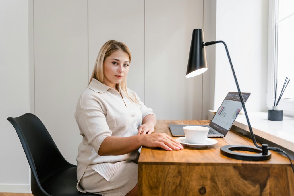 A student using a laptop to compare living expenses and study abroad costs for the USA, Canada, UK, and Australia.
