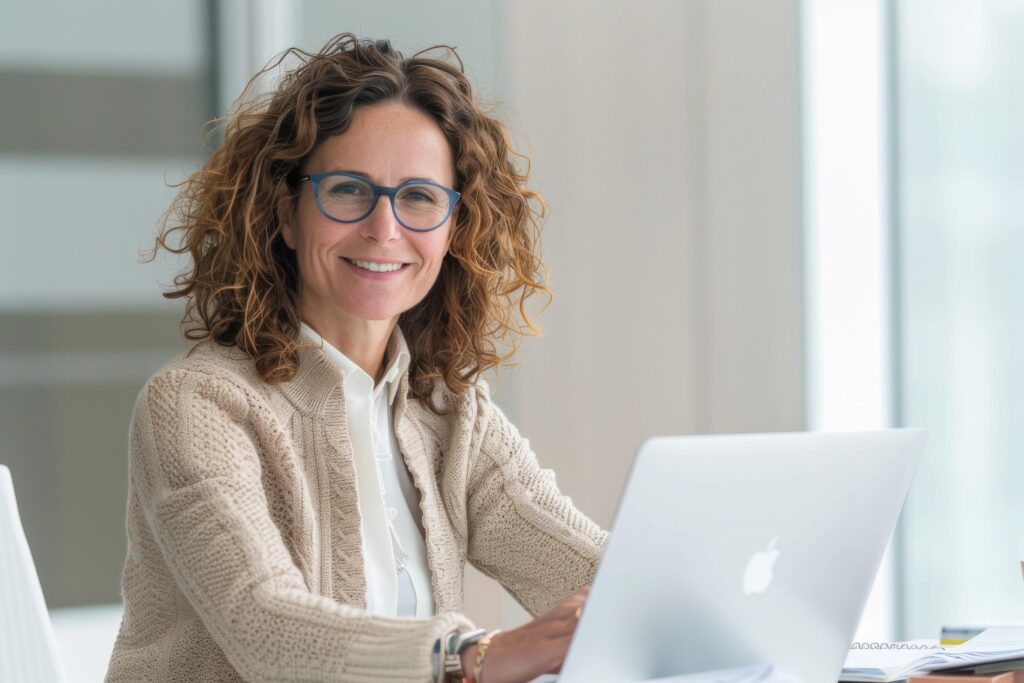 A professional woman working on a laptop while researching cost of living and study abroad expenses for different countries.