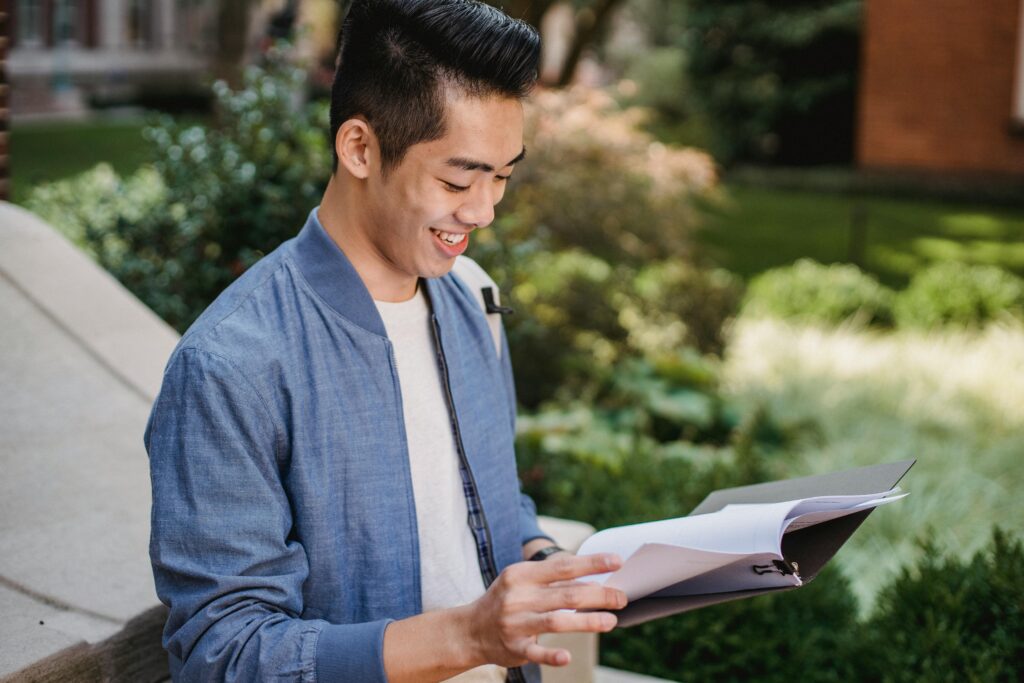 Student reading university admission documents while deciding courses after 12th for studying abroad.