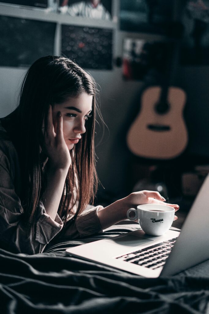 A focused student using a laptop at night while researching study abroad opportunities and preparing for international education.