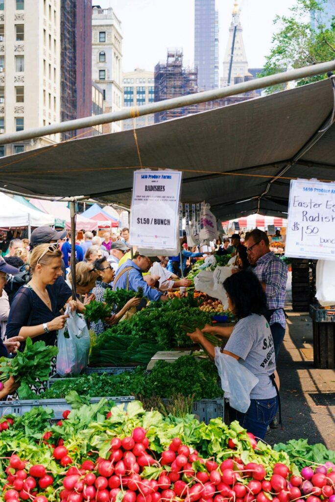 International students buying fresh food at local market while managing monthly living expenses abroad