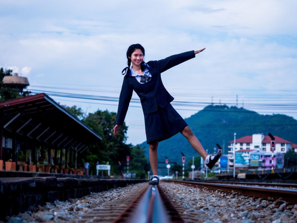 Student balancing on railway track symbolizing choosing the right country and course for study abroad journey