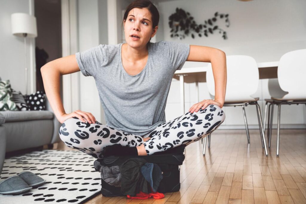 Top Mistakes Students Make While Packing showing student struggling with overpacked suitcase and travel preparation stress