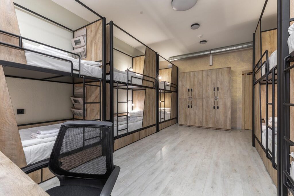 Hostel vs Shared Apartment Abroad: modern student hostel room with bunk beds and shared living space