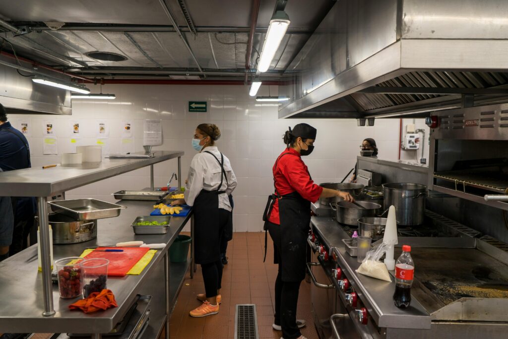 Highest Paying Countries for Fresh Graduates – International kitchen staff working in a professional commercial kitchen abroad