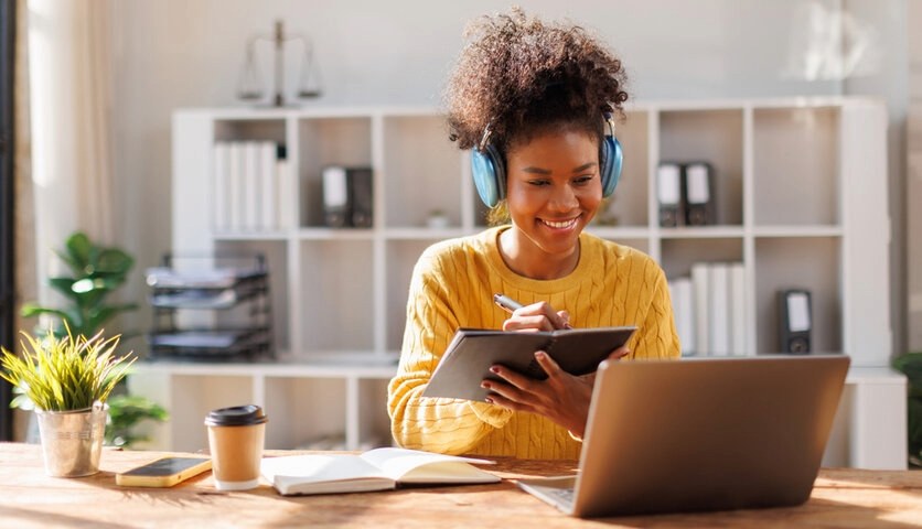 Student Resources featuring an international student studying online with a laptop, digital tablet, headphones, notebook, and educational materials for successful study abroad preparation.